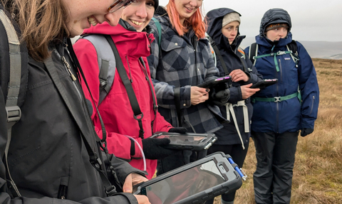 A group of participants on the Peatland Pathways course out on a peat bog recording information on tablets
