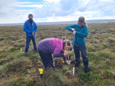 Beth and Tessa measuring the water table with a dipwell