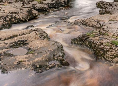 Racing, discoloured water in the Upper Wharfe after heavy rain.